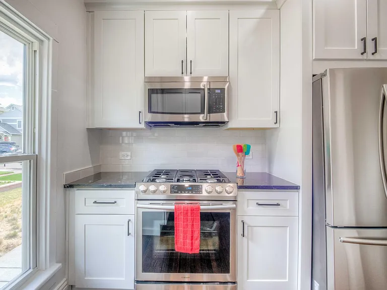 Stove and refrigerator side of kitchen.