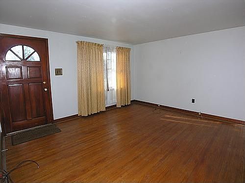 Living room with large picture window and original hardwood floors.