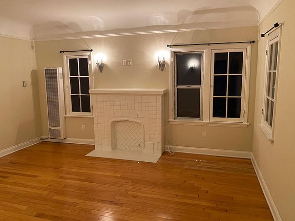 LIVING ROOM WITH HARDWOOD FLOORS BATCHELDER TILE FAUX FIREPLACE AND ANTIQUE SCONES