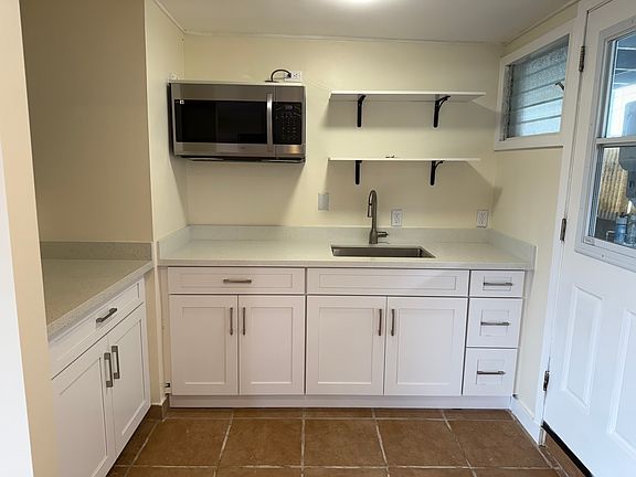 Newly remodeled kitchen with new appliances, sink, countertops, and cabinets.