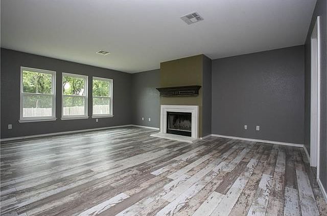 Large living room downstairs with fireplace, opens to the kitchen and overlooks backyard...