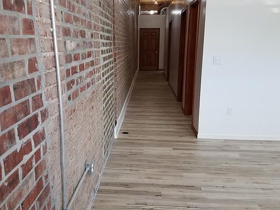 BRICK EXPOSED HALLWAY TO BEDROOMS, KITCHEN AND 2ND BATH