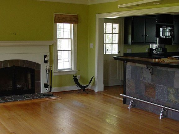 kitchen opens into living room with slate bar and 1 of 3 fireplaces