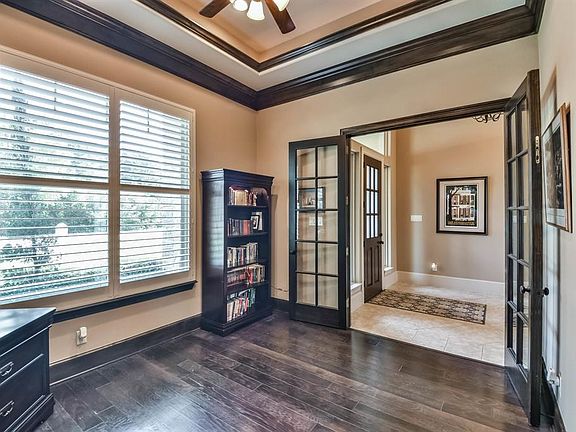 The Study/library showcases built-in bookshelves, wood floors & double French doors.