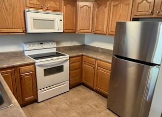 Refrigerator, stove, microwave and dishwasher. Open bar into the living room.