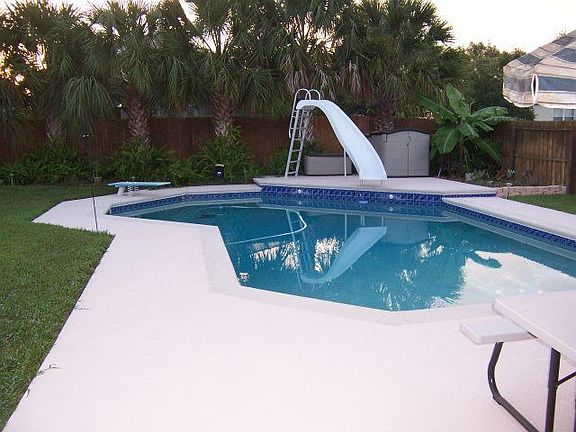 Large swimming pool with diving board and slide