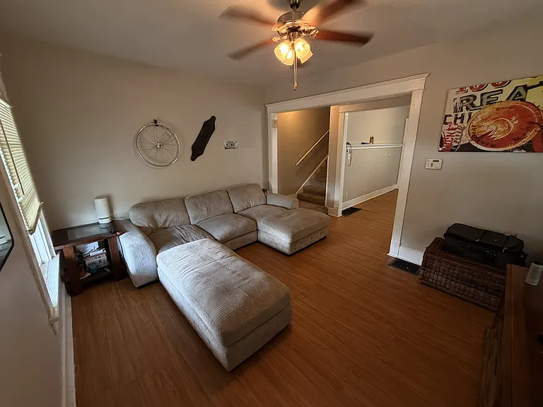 Living area with stairs going to upstairs bedrooms and hallway to kitchen