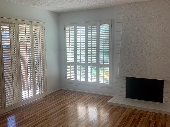 Once inside the front door, the bright and open front room welcomes you. Slider door to the front, private patio, wood blinds, hardwood laminate flooring