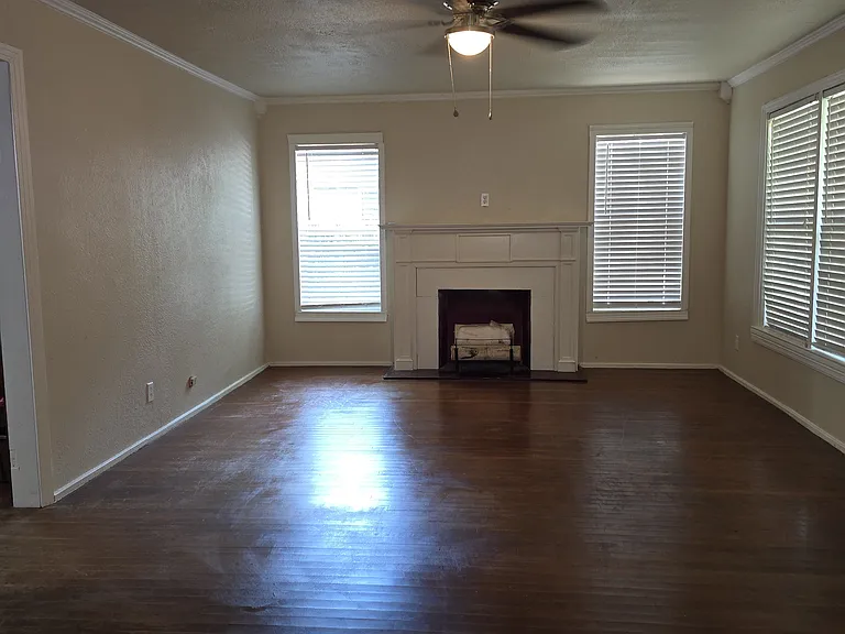 Large formal living room with fireplace and natural light