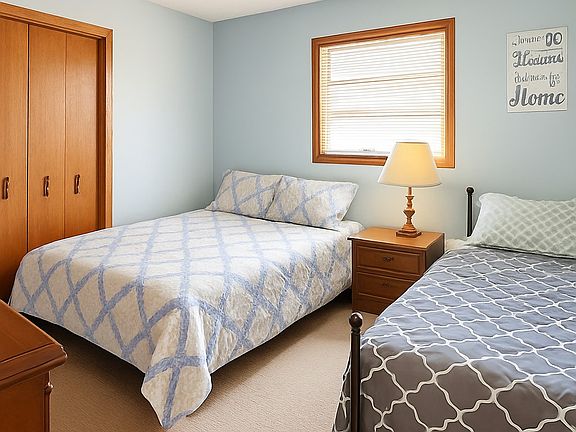 Comfortable twin bedroom with neutral tones and natural light.