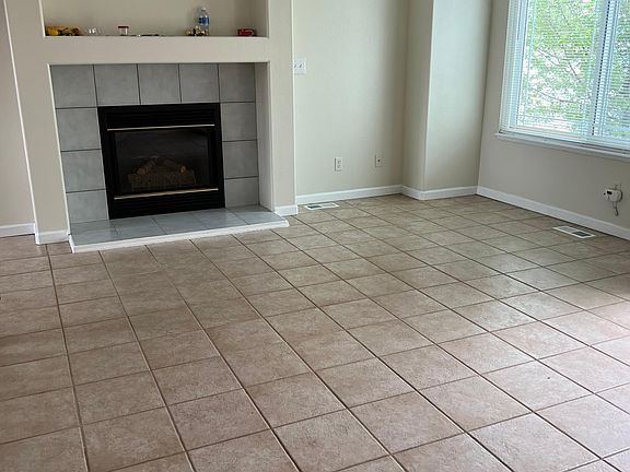 Living room with gas fireplace and ceiling fan.