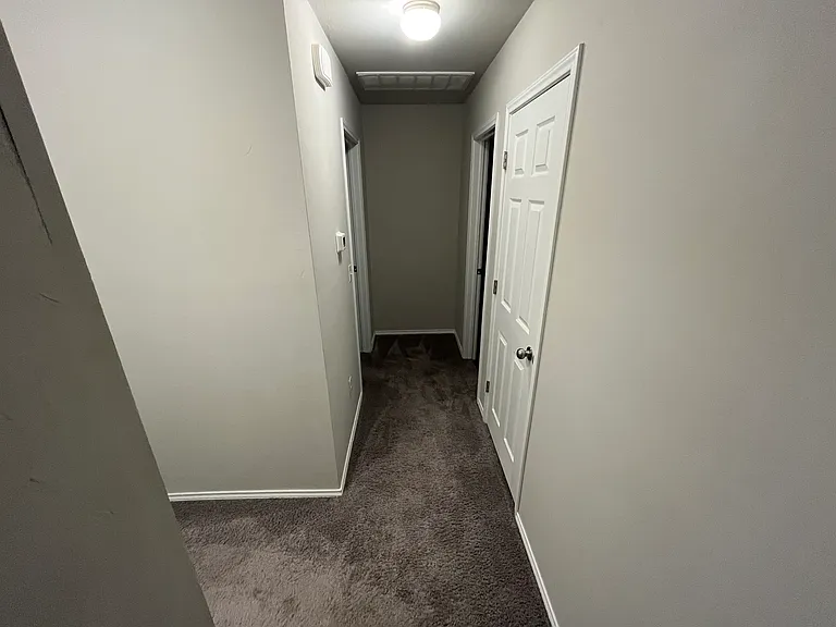 Hallway to bedrooms #2 and #3, secondary bathroom, and utility room/garage