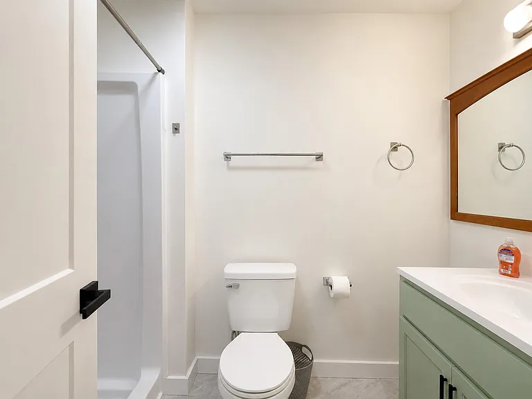 Clean full bath with tub/shower combo, wide vanity with mirror, and convenient towel bars for everyday storage.