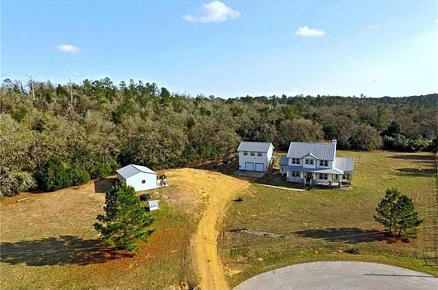 This two-story home was built in Year 2001 by a multi-million dollar lottery winner and due to life style changes, it now has a different owner. It is on a five acres with three acres being trees and woods. There is an outbuilding on slabs and with two ov