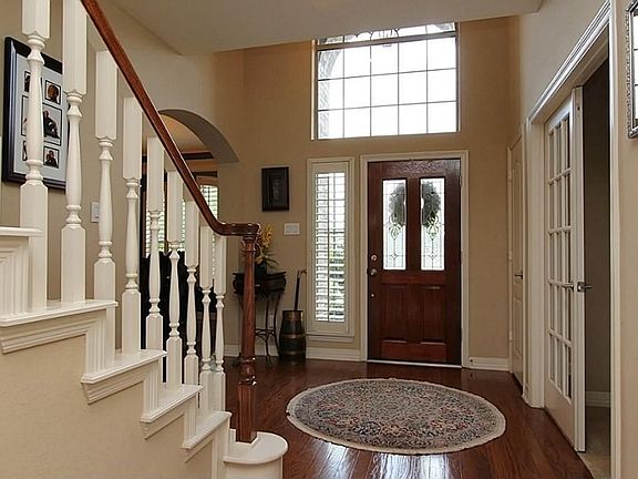 The leaded glass front door opens to hardwood flooring, a soaring ceiling, transom, side window and 