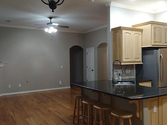 The main level features an open concept layout with the kitchen connecting to the living and dining spaces via a peninsula with bar seating.