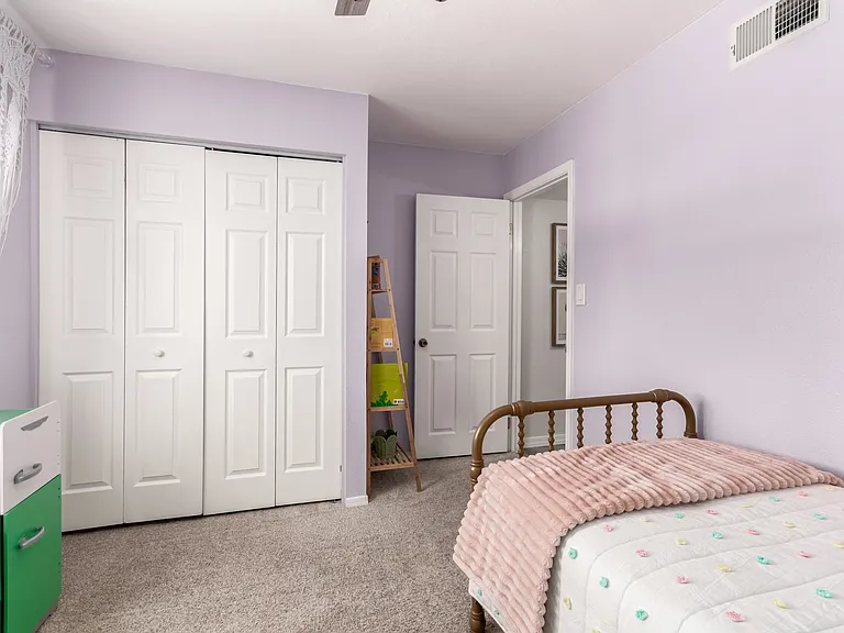 Kid's room with twin bed and crib, books and toys.