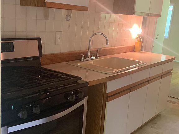 Galley type kitchen with new range and fridge.