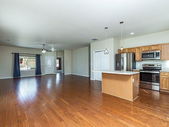 Great room looking from patio towards the front door. Nice wood floor,