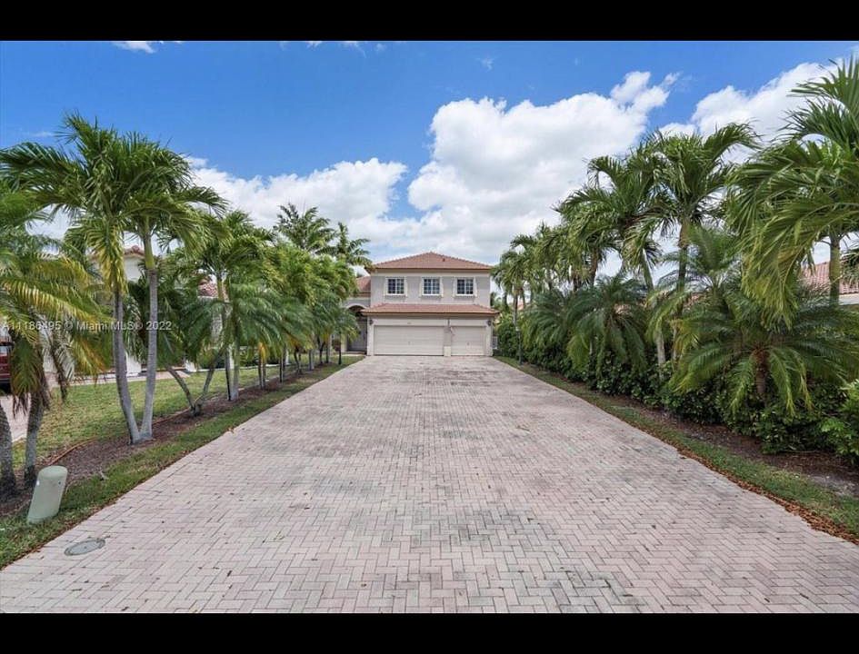 Big elongated driveway which give the property a huge picture with palm trees on the side leading to a 3- car garage