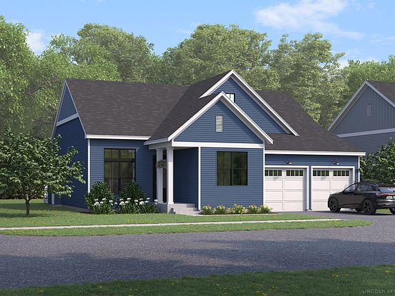 Blue single-story house with white trim, two-car garage, and a driveway, surrounded by trees and gre