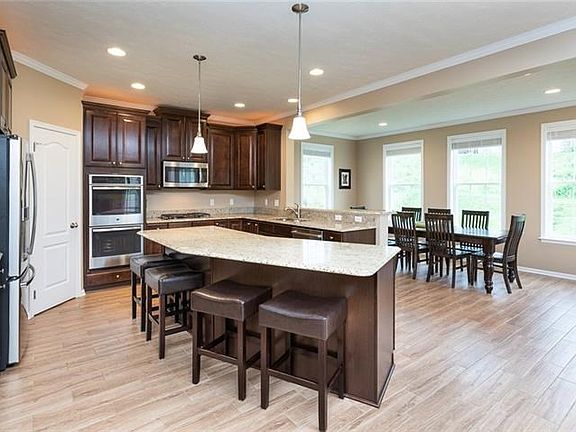 Beautiful open kitchen with 40 inch upper cabinets,Expanded Island,Porcelain tile flooring, Granite counters and upgraded applia