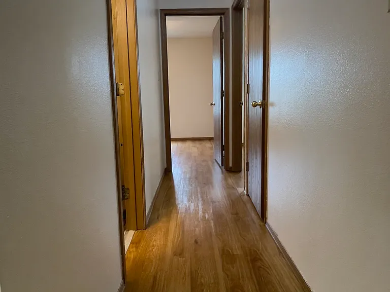 View from the Master Bedroom door, looking down the Hallway. 
The Hall Bathroom is on the left.
The other 2 Bedrooms are at the end and to the right of the hallway.
The floor to ceiling Linen Closet is the 1st door you see on the right.