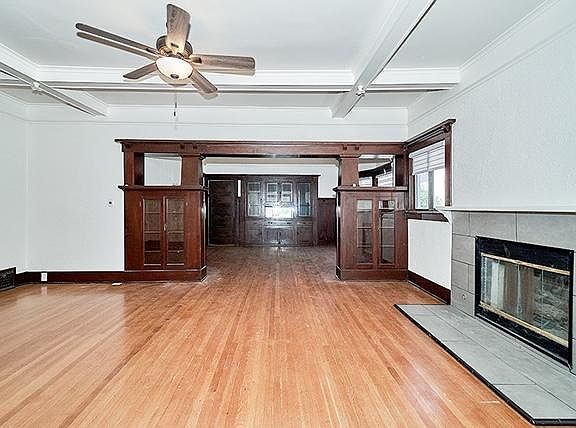 Living room standing from the front entrance. Leads into the formal dining room. Original built-in cabinets with crystal faces. Gas fireplace.