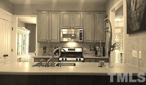 SS Microwave, SS Dual Sink with Custom faucets with sprayer, tile backsplash, and Corian countertop with over hang.