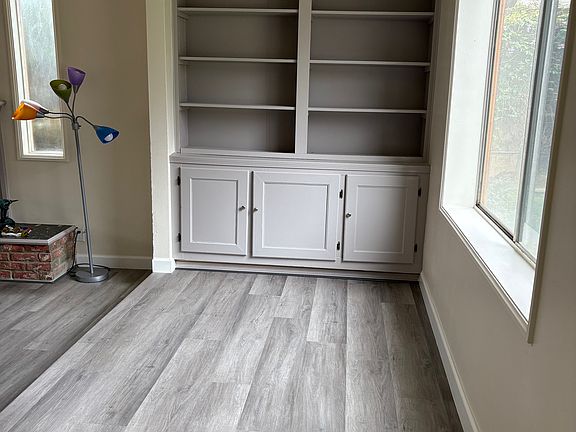 Entry hallway. To the left (not pictured) the coat closet. Straight ahead, bookcase and cabinets
