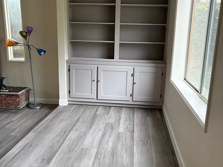 Entry hallway. To the left (not pictured) the coat closet. Straight ahead, bookcase and cabinets