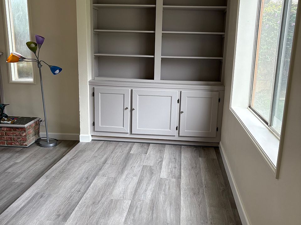 Entry hallway. To the left (not pictured) the coat closet. Straight ahead, bookcase and cabinets