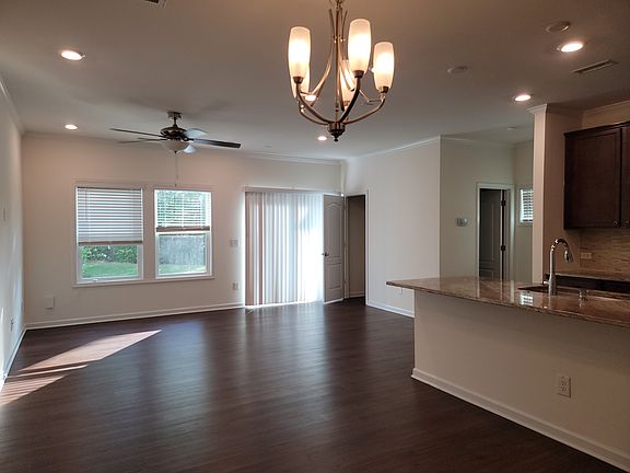 Slide open to your own private wooded backyard _ a rare serene escape where nature meets comfort, right outside your living room. A convenient closet and powder room tucked beside the staircase keep daily life organized and guest-ready at all times.