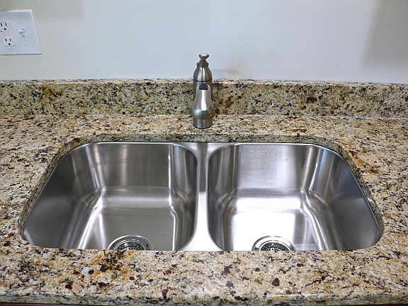 Stainless sink with granite countertops.