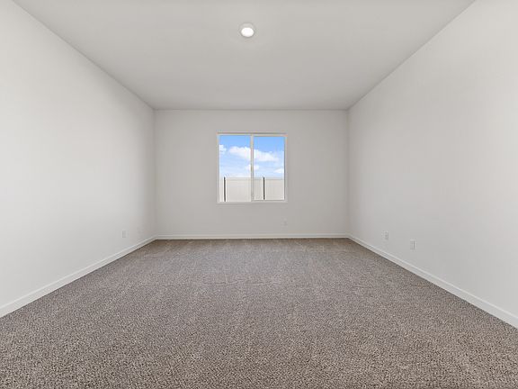 The master bedroom has a large window and is spacious.