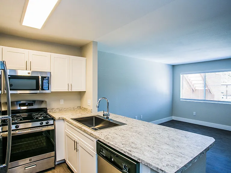Kitchen breakfast bar overlooking apartment living area.