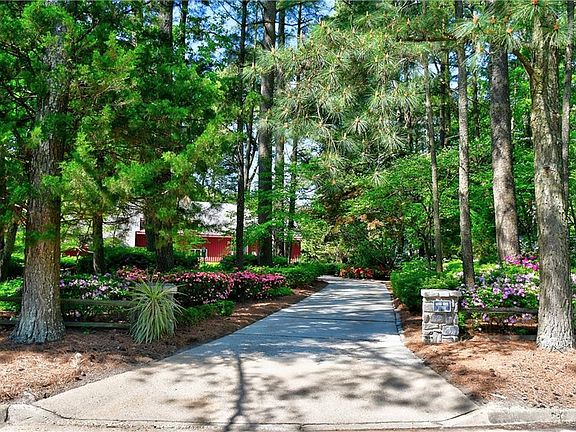 Welcome to Quiet Cove. The cobblestone entrance columns extend a warm "Welcome to Quiet Cove" with the sign on the right column from North River Road.
