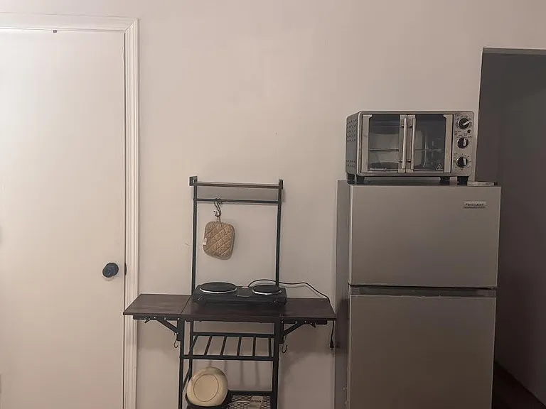Compact kitchenette area with a mini fridge, countertop oven, and small prep station for convenient everyday meals.
