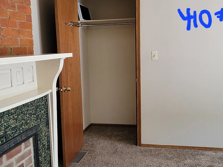 Bedroom with decorative mantle piece and closet.