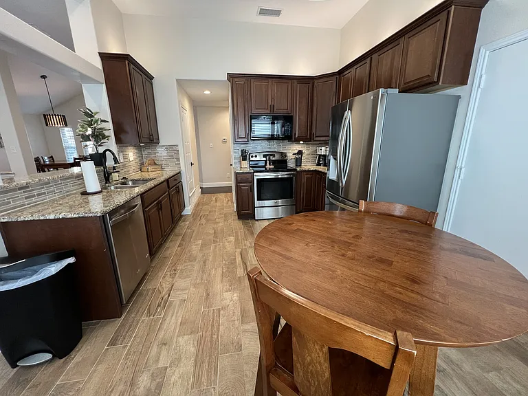Fully furnished kitchen and breakfast area with modern finishes and ample storage.