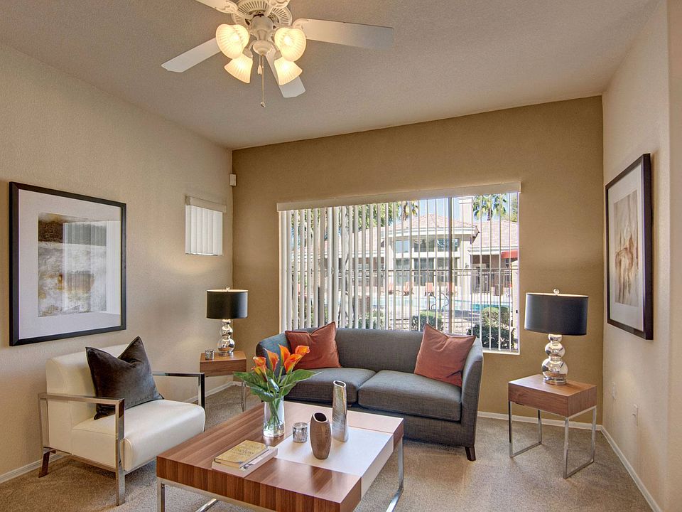 A living room with a ceiling fan and overhead lighting