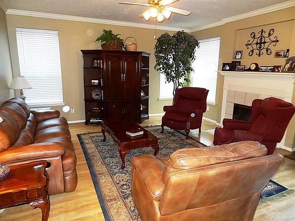 Family room with ceiling fan, crown molding, fluted molding around gas fireplace