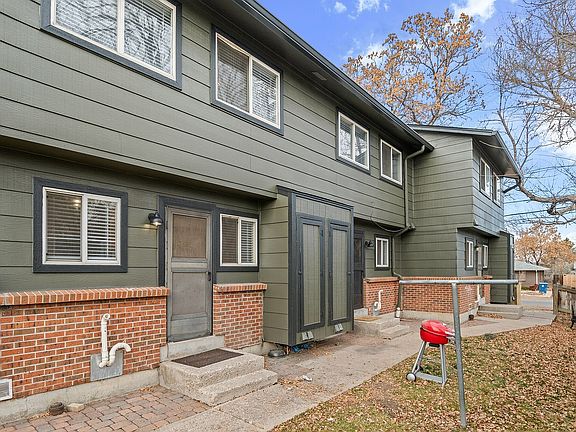 Explore this inviting townhouse with its unique green and brick exterior, perfect for modern living.