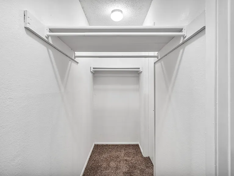 Walk-in closet with shelving and generous storage space.