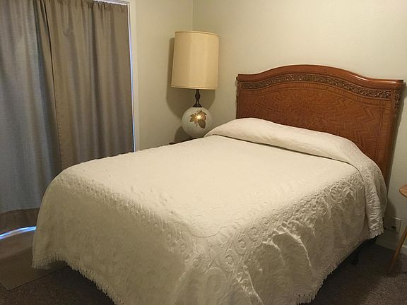 Bedroom with slider leading out to side yard.