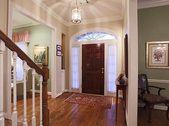 The front entry welcomes you with planked art niches, beautiful hardwood floors, and leads you to either the dining or living room.