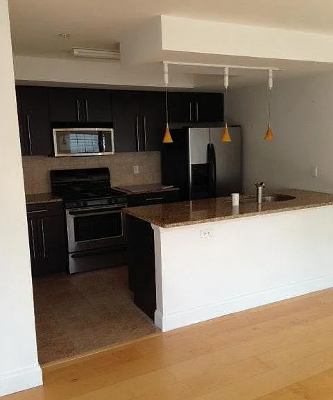 Open Kitchen with Stainless Steel Appliances and granite cou