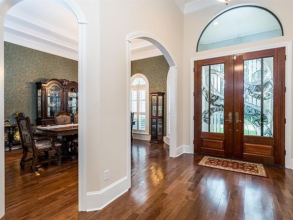 Elegant foyer with high ceilings and wood floors that can be found in the living spaces.