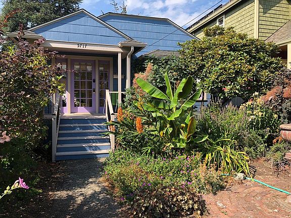 Storybook bungalow in cheery colors with tropical garden.