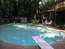 Pool   screened in patio overlook a large estate with horses